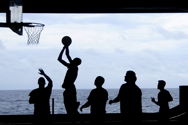 Silhouettes of five adults playing basketball